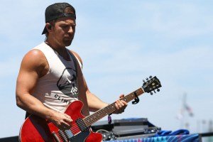 Archival photo of Kip Moore playing guitar outdoors