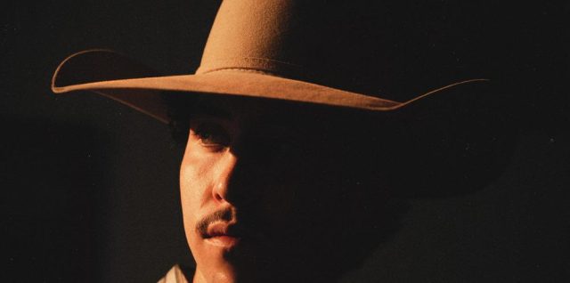 Mack Geiger wearing a cowboy hat on the Dying In This House album cover