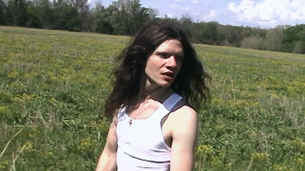 Sawyer Hill outdoors in a field in the Lady Arkansas music video